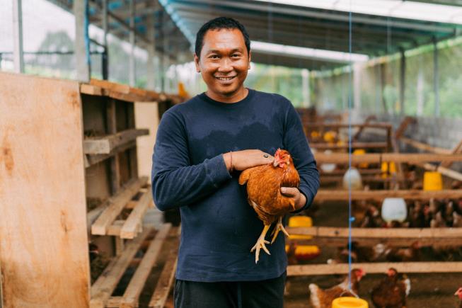 Ngurah Heru Wijaya, owner of Jero.Farm, holding a healthy free-range chicken